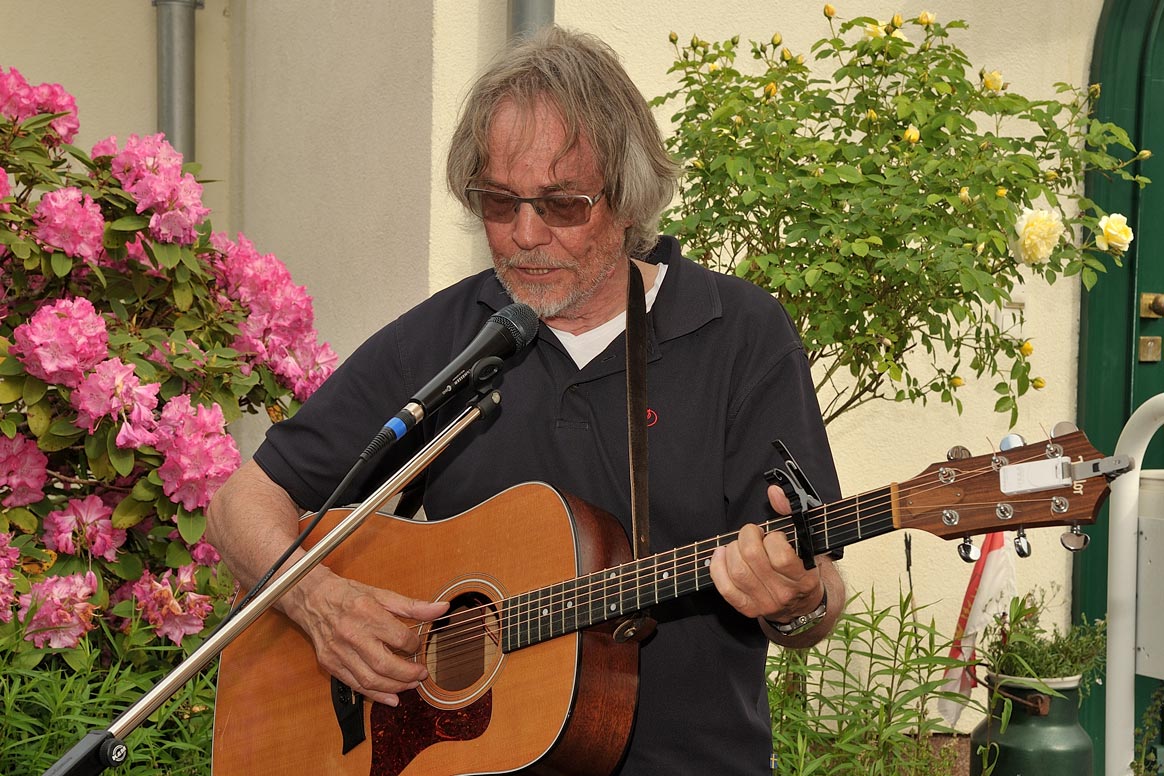 Der Liedermacher Peter Mehlfeld trägt sein Lied über Manfred Faber vor